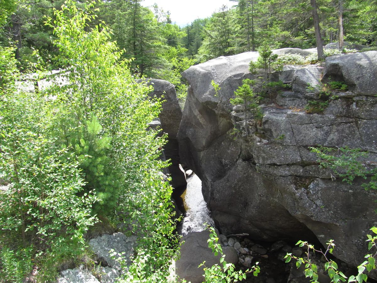 Screw Auger Falls cascading through a narrow granite gorge in Grafton Notch State Park, Maine